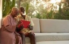 Older couple laughing at something on iPad