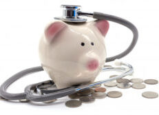 Piggy bank getting checked by stethoscope and surrounded by coins