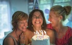 Photo of three women with a birthday cake