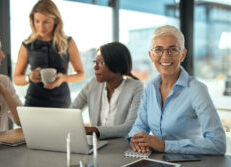 Photo of older woman at work with colleagues