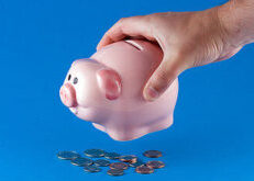Hand emptying a piggy bank